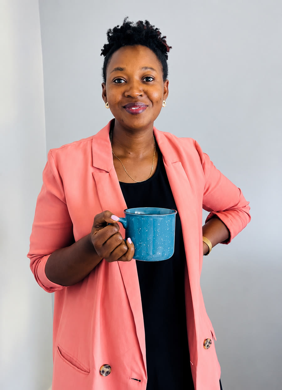 Coach Banura of Eat Better UG holding a cup of tea