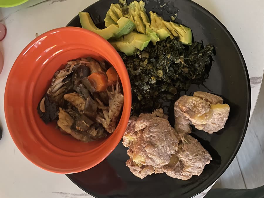 A balanced home-cooked meal of greens, avocado, stew and matooke